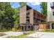 Modern home featuring wood accents, large windows, and a carport with manicured landscaping at 922 Tower St, Raleigh, NC 27607