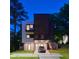 Modern home at dusk featuring a covered parking area, balconies, and contemporary design at 922 Tower St, Raleigh, NC 27607