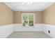 Bright bedroom with wainscoting, window, and neutral carpet throughout at 9416 Buggy Run Cir, Wake Forest, NC 27587