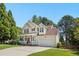 Inviting two-story home with a cozy front porch, attached garage, and lush surrounding greenery on a sunny day at 9416 Buggy Run Cir, Wake Forest, NC 27587