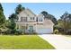 Charming two-story home boasts a welcoming porch, a well-manicured lawn, and an attached two car garage at 9416 Buggy Run Cir, Wake Forest, NC 27587