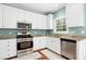 Bright kitchen with white cabinets, granite countertops, stainless steel appliances, and natural light streaming through the window at 9416 Buggy Run Cir, Wake Forest, NC 27587