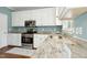 Well-lit kitchen featuring white cabinets, granite countertops, and stainless steel appliances with natural light from the window at 9416 Buggy Run Cir, Wake Forest, NC 27587