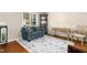Cozy living room featuring hardwood floors, a comfortable blue sofa, and natural light streaming through a large window at 9416 Buggy Run Cir, Wake Forest, NC 27587