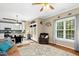 Open-concept living area with kitchen access, plush seating, and natural light streaming in from multiple windows and doors at 9416 Buggy Run Cir, Wake Forest, NC 27587