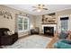 Cozy living room featuring a fireplace, hardwood floors, and natural light from the window at 9416 Buggy Run Cir, Wake Forest, NC 27587