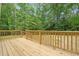 Large wooden back deck with railings overlooks a private, wooded backyard with lush green trees at 1004 Snow Peak Ct, Raleigh, NC 27603