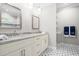 Elegant bathroom features double vanity with granite counters, tiled floors, mirrors and lighting at 1004 Snow Peak Ct, Raleigh, NC 27603