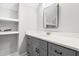 This gray bathroom vanity has a quartz countertop, black hardware, a framed mirror, and is paired with open shelves at 1004 Snow Peak Ct, Raleigh, NC 27603