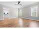 Bright bedroom with hardwood floors, large window, and a modern ceiling fan at 1004 Snow Peak Ct, Raleigh, NC 27603