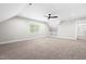 Spacious bonus room with carpet, built-in shelving, a ceiling fan, and ample natural light from a large window at 1004 Snow Peak Ct, Raleigh, NC 27603