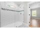This bathroom features a glass enclosed shower with white subway tile and decorative blue and gray border and matching floor tile at 1004 Snow Peak Ct, Raleigh, NC 27603