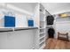 A large walk-in closet with custom shelving and dark metal rods, complemented by wood flooring and a small bench at 1004 Snow Peak Ct, Raleigh, NC 27603