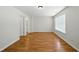 A well-lit bedroom boasts hardwood floors, a window, and a doorway at 110 Virens Dr, Cary, NC 27511