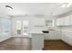 Bright kitchen with white cabinetry, modern appliances, and a breakfast bar with easy access to the patio doors at 110 Virens Dr, Cary, NC 27511