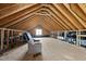 Unfinished attic space with exposed wooden beams, a window, and ample storage at 1123 Ambrose Dr, Rolesville, NC 27571