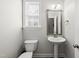 Clean and bright half bathroom with a pedestal sink, window, and neutral decor at 1123 Ambrose Dr, Rolesville, NC 27571