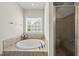 Bathroom featuring a soaking tub, tiled surround, and a separate glass-enclosed shower at 1123 Ambrose Dr, Rolesville, NC 27571