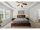 Bright bedroom with a tray ceiling, ceiling fan, and several windows at 1123 Ambrose Dr, Rolesville, NC 27571