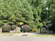 Entrance to the community featuring brick pillars, mature trees, lush bushes, and a park bench at 1123 Ambrose Dr, Rolesville, NC 27571