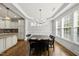 Eat in area with dark wood table, hardwood floors, chandelier, large window and tray ceiling at 1123 Ambrose Dr, Rolesville, NC 27571