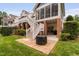 Backyard with brick patio, outdoor seating, stairs to the deck, and lawn at 11571 Auldbury Way, Raleigh, NC 27617