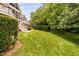 View of the backyard with patio, deck, lawn, and mature trees at 11571 Auldbury Way, Raleigh, NC 27617