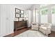 Bright bedroom featuring wood floors, a large dresser, and seating under a window at 11571 Auldbury Way, Raleigh, NC 27617