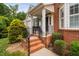 Charming front porch featuring brick steps, a bench, and manicured landscaping at 11571 Auldbury Way, Raleigh, NC 27617