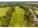 Scenic aerial shot of a golf course featuring pristine green fairways and scattered trees at 11571 Auldbury Way, Raleigh, NC 27617