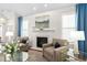 Bright living room features a fireplace, neutral armchairs, and shuttered windows at 11571 Auldbury Way, Raleigh, NC 27617