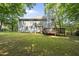 Backyard with large grassy yard, and a beautiful two-story house with a wooden deck at 116 Hidden Cellars Dr, Holly Springs, NC 27540