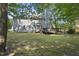 Backyard with large grassy yard, and a beautiful two-story house with a wooden deck at 116 Hidden Cellars Dr, Holly Springs, NC 27540