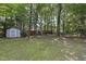 Spacious backyard with a storage shed and mature trees providing privacy at 116 Hidden Cellars Dr, Holly Springs, NC 27540