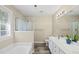 Bright bathroom features a soaking tub, a glass shower enclosure, and a double vanity with sleek fixtures at 116 Hidden Cellars Dr, Holly Springs, NC 27540