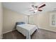 Neutral bedroom features a ceiling fan and a comfortable bed with blue pillows, complemented by shuttered windows at 116 Hidden Cellars Dr, Holly Springs, NC 27540