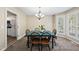 Cozy dining room features natural lighting, carpeted floors, and a modern chandelier at 116 Hidden Cellars Dr, Holly Springs, NC 27540