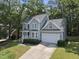 Charming two-story home with attached garage, manicured landscaping, and mature trees at 116 Hidden Cellars Dr, Holly Springs, NC 27540