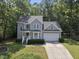 Charming two-story home with attached garage, manicured landscaping, and mature trees at 116 Hidden Cellars Dr, Holly Springs, NC 27540
