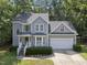 Charming two-story home with attached garage, manicured landscaping, and mature trees at 116 Hidden Cellars Dr, Holly Springs, NC 27540