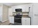 Kitchen with laminate floors, white cabinets, modern oven and countertops at 116 Hidden Cellars Dr, Holly Springs, NC 27540