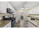 Well-lit kitchen features laminate flooring, white cabinets, and modern appliances at 116 Hidden Cellars Dr, Holly Springs, NC 27540