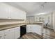 Bright kitchen with laminate floors, white cabinets, and stainless steel sink at 116 Hidden Cellars Dr, Holly Springs, NC 27540