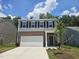 Home featuring a gray exterior, black shutters, brick accents, and a two-car garage at 126 N Keatts Winner Ct, Wilson's Mills, NC 27520