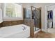 Bathroom featuring a soaking tub, enclosed shower, and a window letting in natural light at 149 Hadley Ln, Clayton, NC 27527