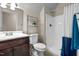 Small bathroom with a toilet, vanity and a shower behind a glass door with shelving for organizing supplies at 149 Hadley Ln, Clayton, NC 27527