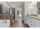 Bathroom featuring a granite countertop, white cabinets, soaking tub, and glass shower at 149 Hadley Ln, Clayton, NC 27527