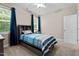 Bright bedroom featuring neutral walls, a ceiling fan, and a cozy bed by a large window with curtains at 149 Hadley Ln, Clayton, NC 27527