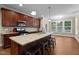 A kitchen showcases a granite island, pendant lights, brown cabinets, stainless steel appliances, and a breakfast nook at 149 Hadley Ln, Clayton, NC 27527