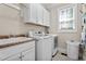 Bright laundry room featuring modern washer and dryer units, sink and natural light at 149 Hadley Ln, Clayton, NC 27527